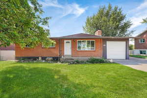 Single story home with brick siding, a front yard, a chimney, concrete driveway, and a garage