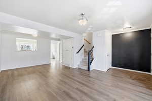Foyer with stairs, light wood-style flooring, and crown molding