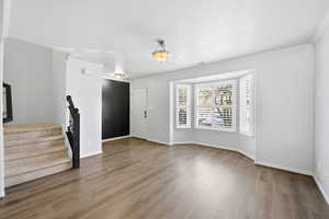 Foyer with stairs, light wood-type flooring, and ornamental molding