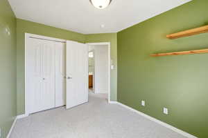 Unfurnished bedroom with carpet and a closet