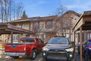 View of front of property with uncovered parking and stone siding