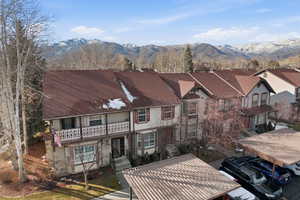 View of front facade with stone siding, a mountain view, a residential view, and stucco siding