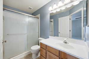 Bathroom with a stall shower, vanity, and light tile patterned flooring