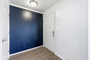 Spare room with ornamental molding and wood finished floors