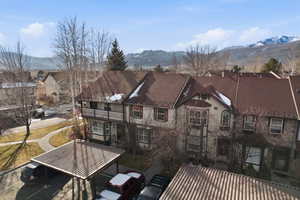 Back of property featuring a mountain view, a balcony, and a residential view