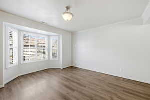 Unfurnished room featuring ornamental molding and wood finished floors