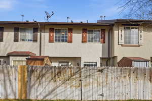 View of front facade with a fenced front yard and stucco siding