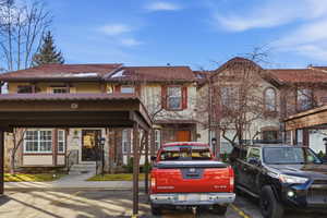 View of front of house featuring stone siding and uncovered parking