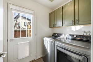 Laundry room featuring cabinet space, separate washer and dryer, and light wood finished floors