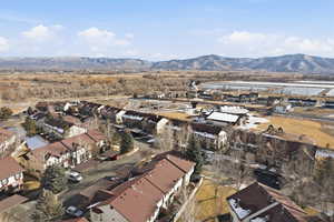 Aerial view of property's location featuring a mountainous background and nearby suburban area