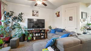 Carpeted living area with ceiling fan