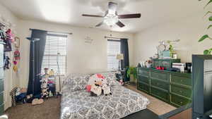 Bedroom featuring dark carpet and ceiling fan