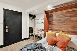 Bedroom featuring a closet, wood finished floors, wooden walls, and recessed lighting