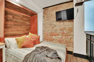 Bedroom with light wood-style flooring and wooden walls