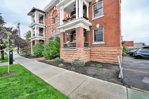 View of side of property featuring brick siding and uncovered parking