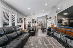 Living area featuring vaulted ceiling, recessed lighting, and dark wood finished floors
