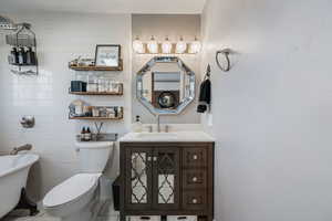 Bathroom with vanity, a freestanding bath, tile walls, and tile patterned floors
