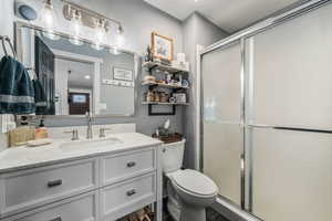 Full bath with vanity, a stall shower, and dark tile patterned floors