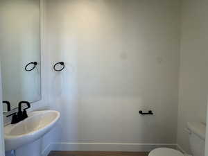 Half bathroom with baseboards and toilet