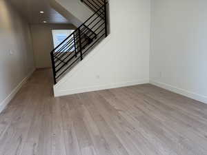 Living room with light wood-type flooring, stairs, and recessed lighting