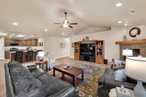 Living room featuring recessed lighting, lofted ceiling, light wood-style flooring, and a ceiling fan