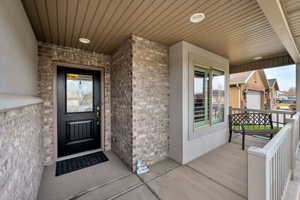Property entrance with covered porch and brick siding