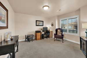 Office space with light colored carpet and baseboards