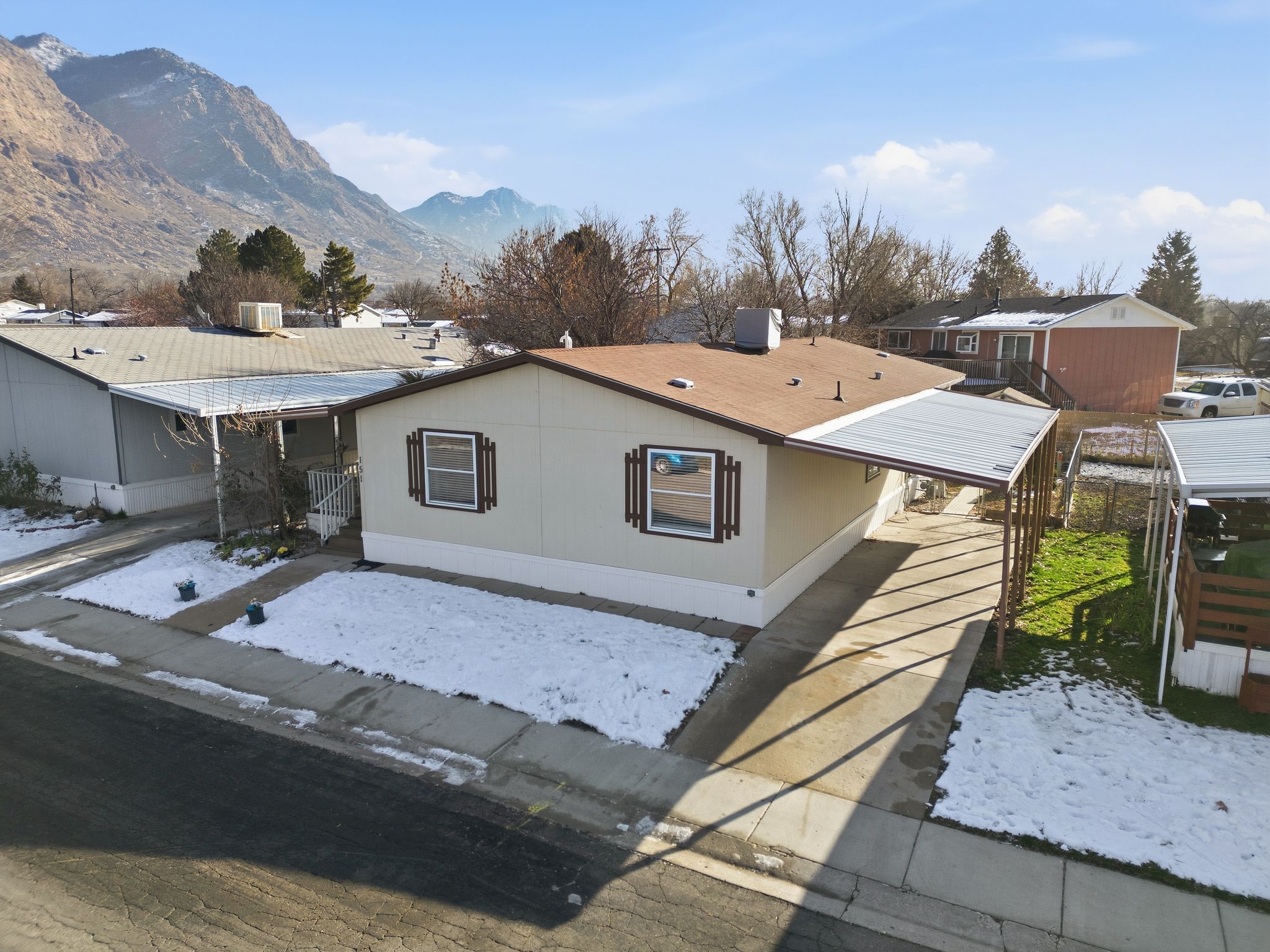 View of front of property featuring a carport, a mountain view, and a shingled roof