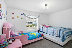 Carpeted bedroom featuring a textured ceiling