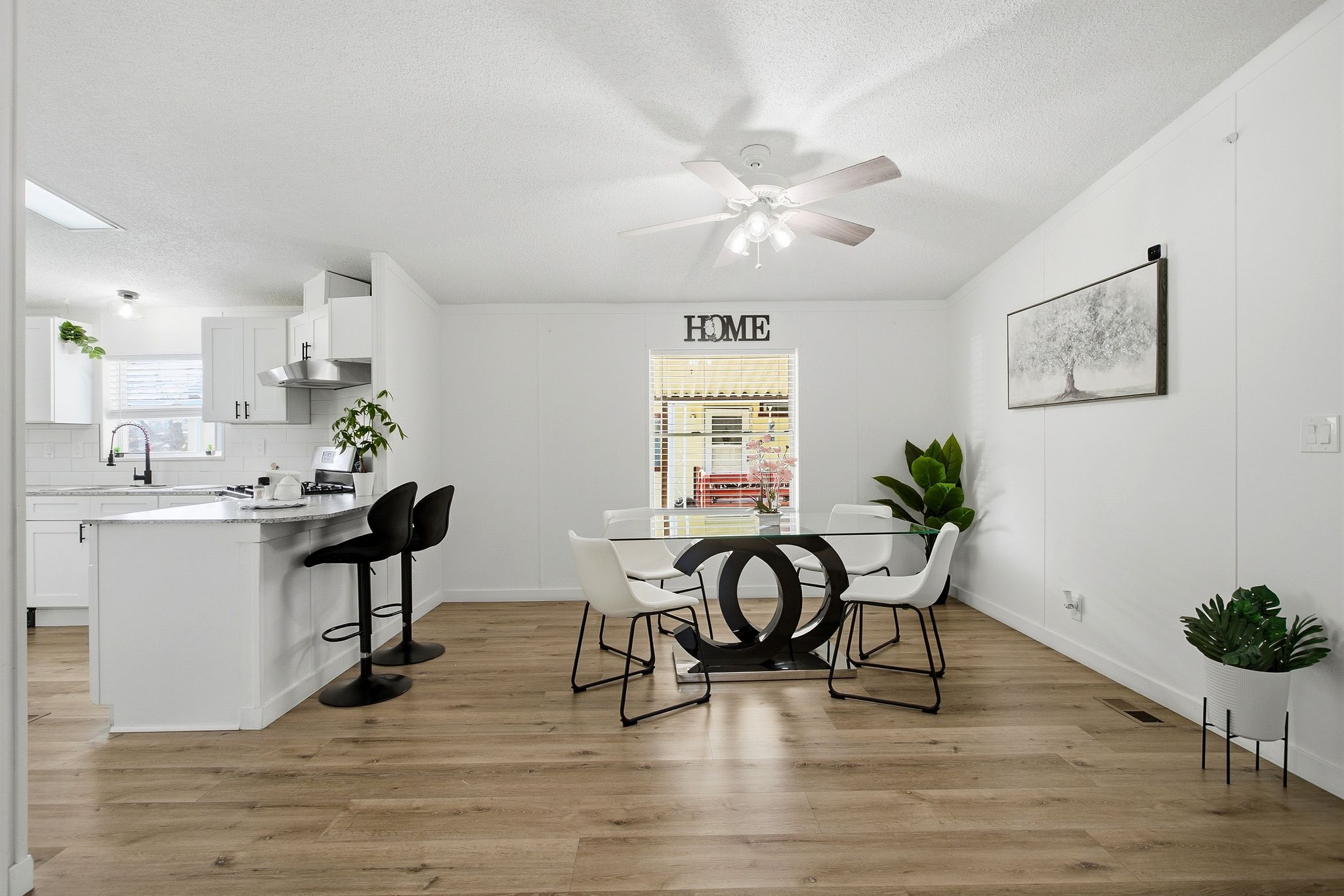 Dining space featuring light wood-style floors, a textured ceiling, and ceiling fan