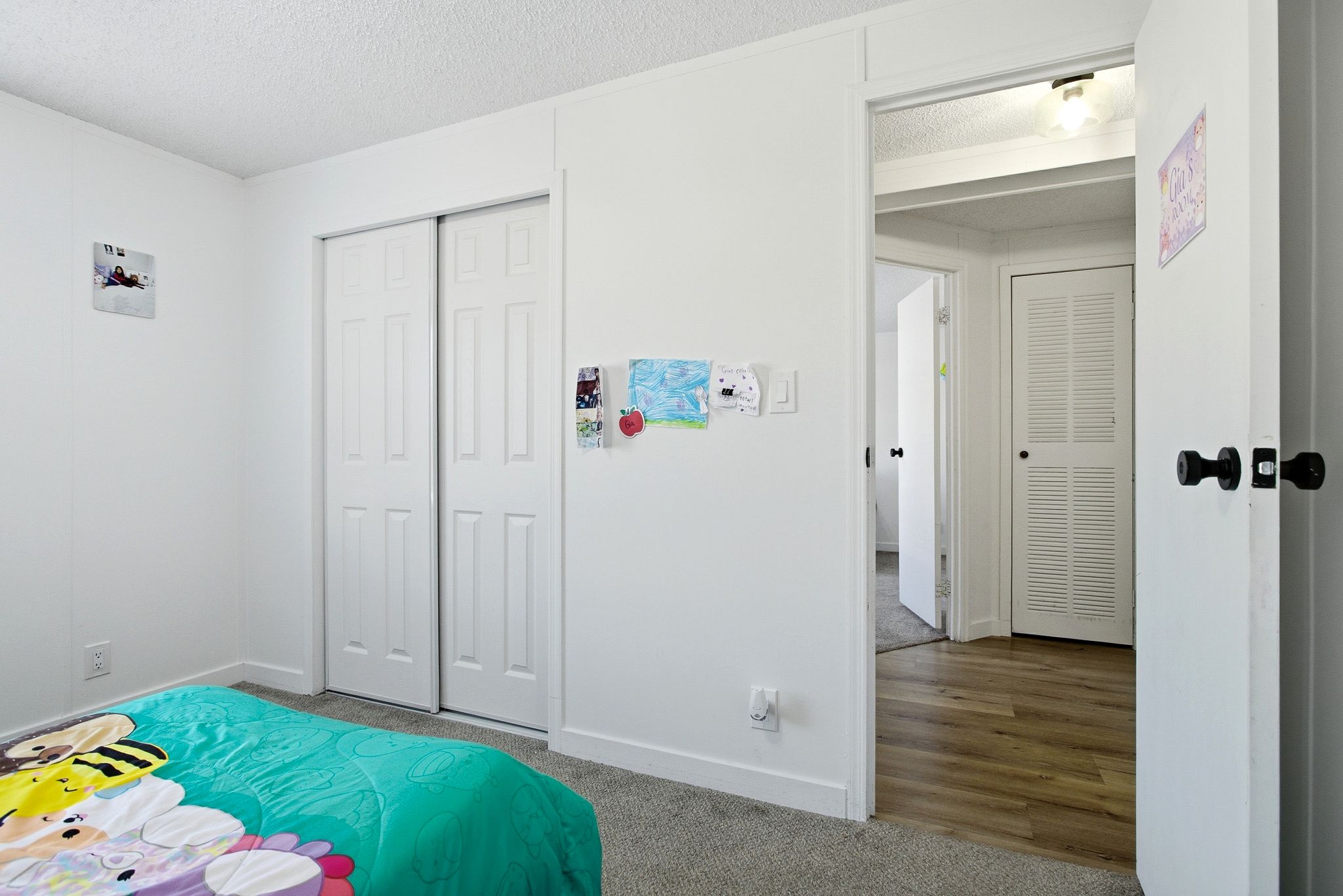 Carpeted bedroom featuring a textured ceiling and a closet