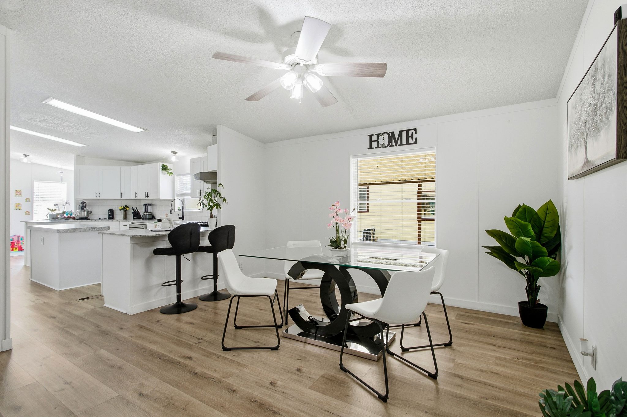 Dining space with a textured ceiling, a ceiling fan, and light wood-style floors