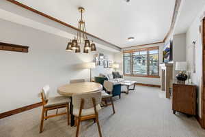 Dining room featuring light colored carpet and a chandelier