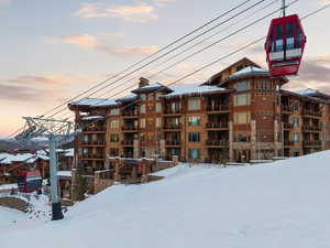 Snow covered property with a view of apartment building / complex