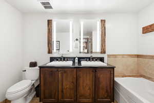 Bathroom featuring a bath and double vanity