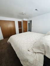 Bedroom featuring a closet and dark colored carpet