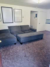 Living room with dark colored carpet and a textured ceiling