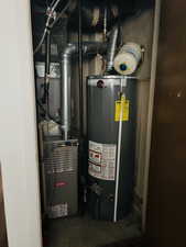 Utility room featuring gas water heater and heating unit