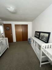 Corridor with a textured ceiling and dark carpet