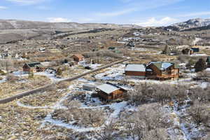 Snowy aerial view featuring a mountain view and a residential view