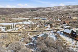 Snowy aerial view featuring a mountain view and a residential view