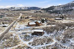 Snowy aerial view with a mountain view and a residential view