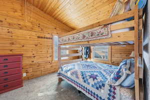 Bedroom featuring wood ceiling, lofted ceiling, wooden walls, carpet, and multiple windows