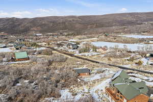 Snowy aerial view featuring a residential view and a mountain view