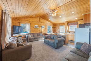 Living room with lofted ceiling, wood ceiling, healthy amount of natural light, recessed lighting, and a ceiling fan