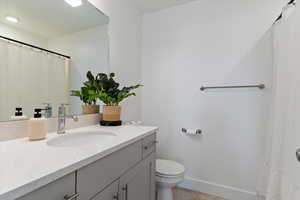 Full bathroom with curtained shower and vanity