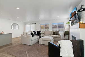 Living area featuring a large fireplace, recessed lighting, and parquet flooring