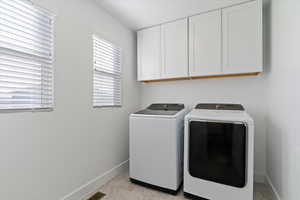Laundry room featuring cabinet space and separate washer and dryer