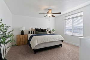 Carpeted bedroom featuring a ceiling fan and baseboards