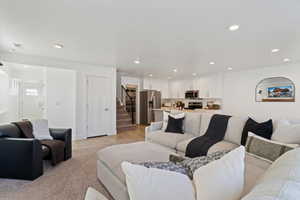 Living area featuring stairs, light wood-style flooring, and recessed lighting